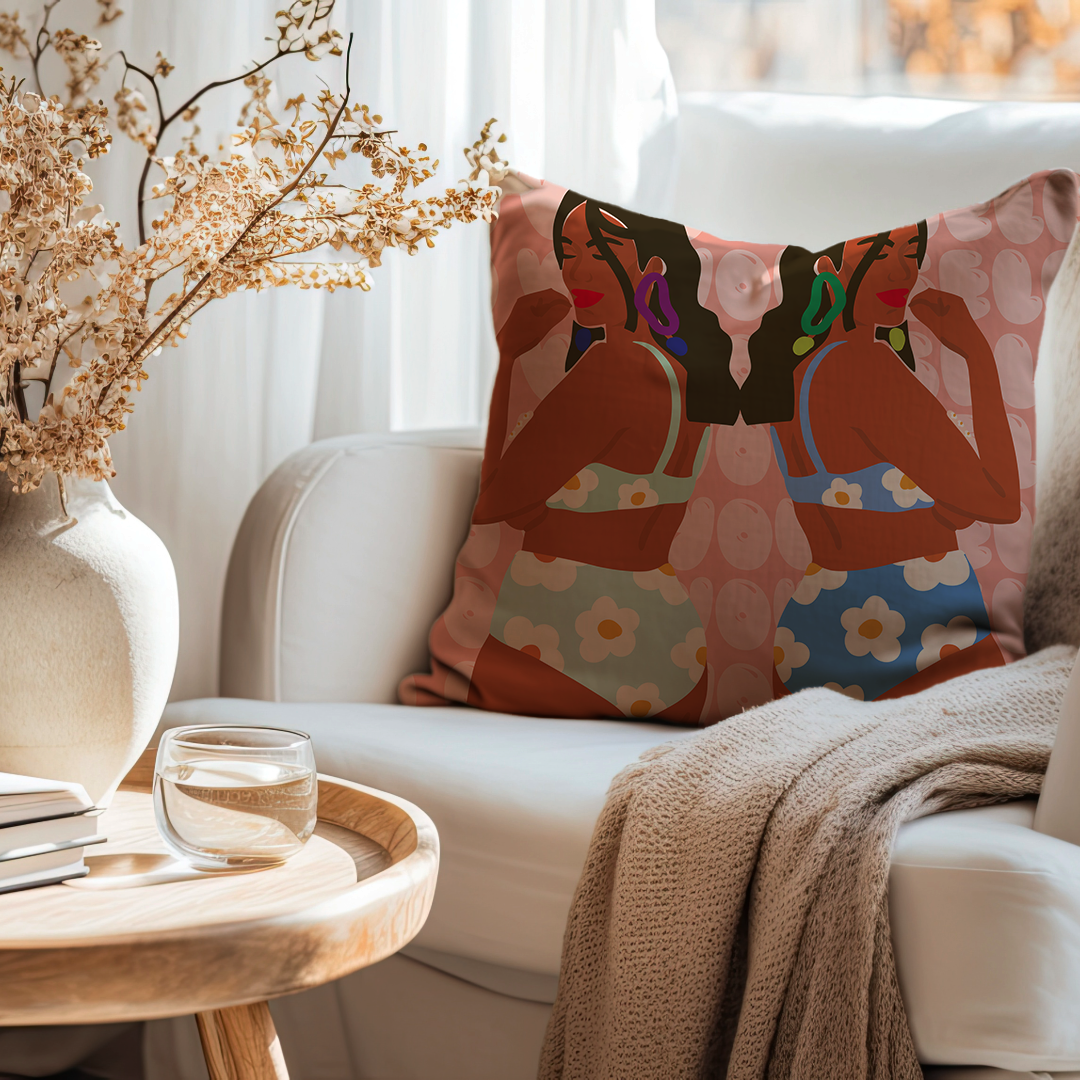Decorative cushion cover with artistic mirrored illustration of two women in colourful floral swimwear against a peach background with circular patterns, perfect for modern boho home décor.
