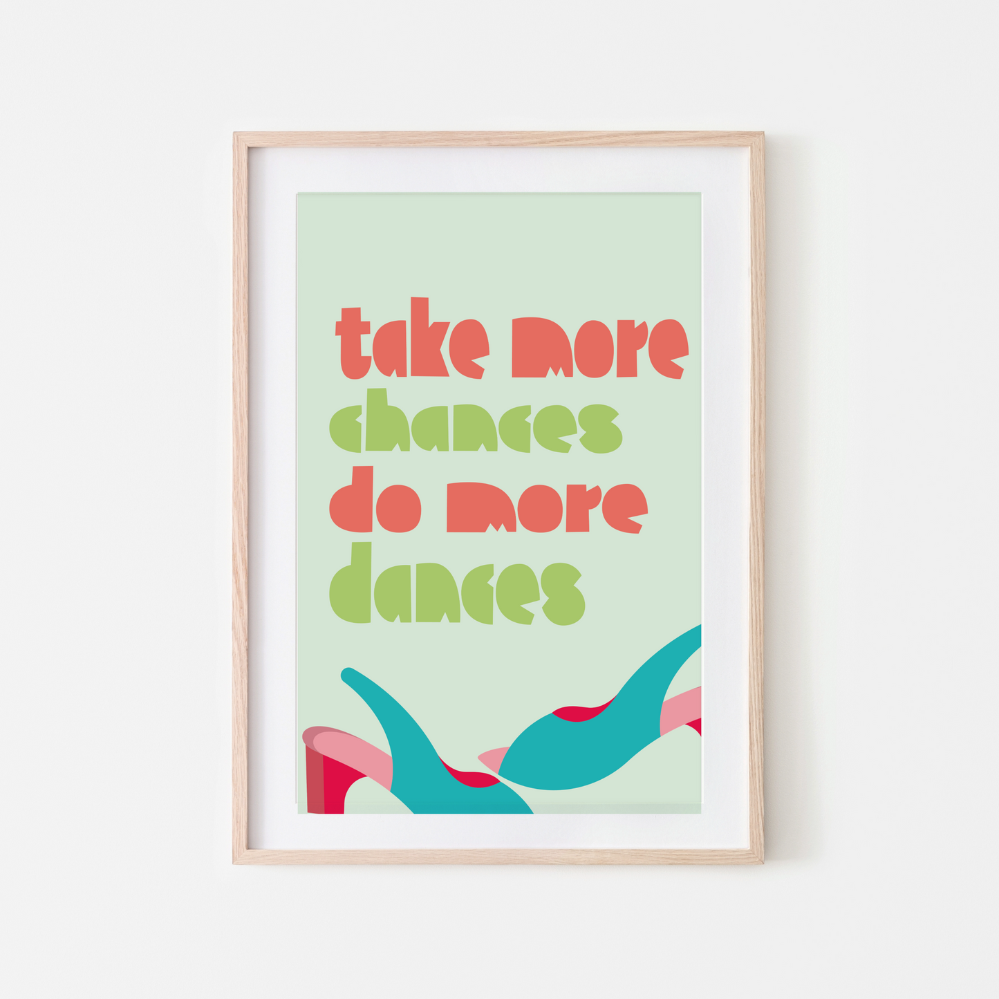 Framed wall art print with the motivational quote "Take More Chances, Do More Dances" in bold, colourful typography on a light green background, featuring abstract shapes.