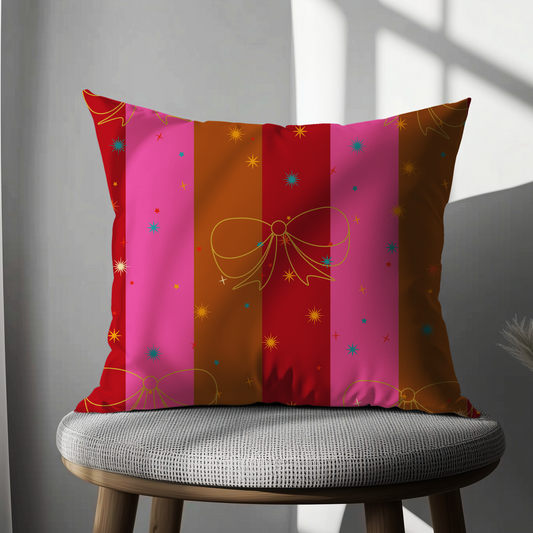 Decorative pillow with colorful stripes and bows on a gray chair.