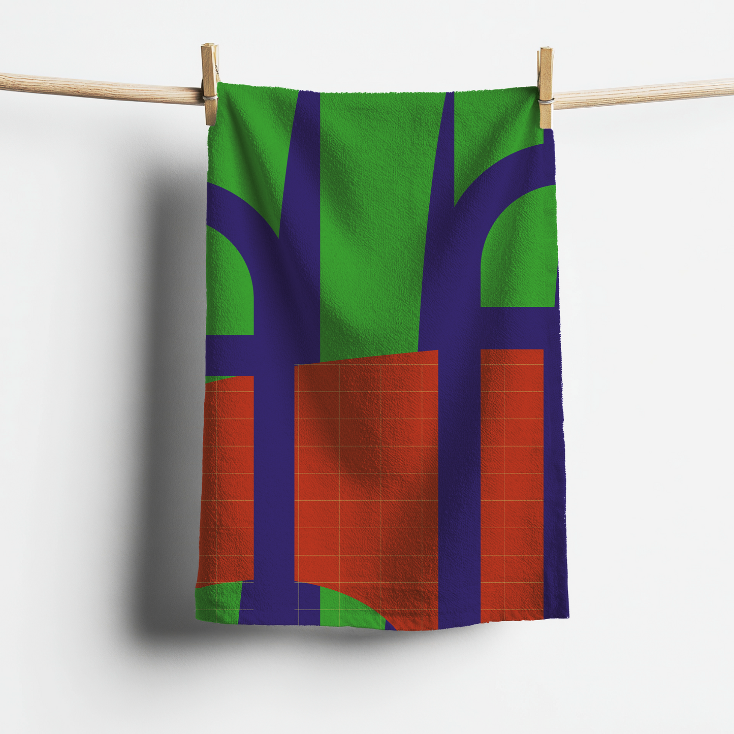 Colorful towel with abstract design hanging on a clothesline against a white background