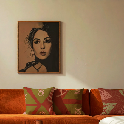A framed portrait painting of a woman hangs on a beige wall above an orange sofa with patterned green and red throw pillows.