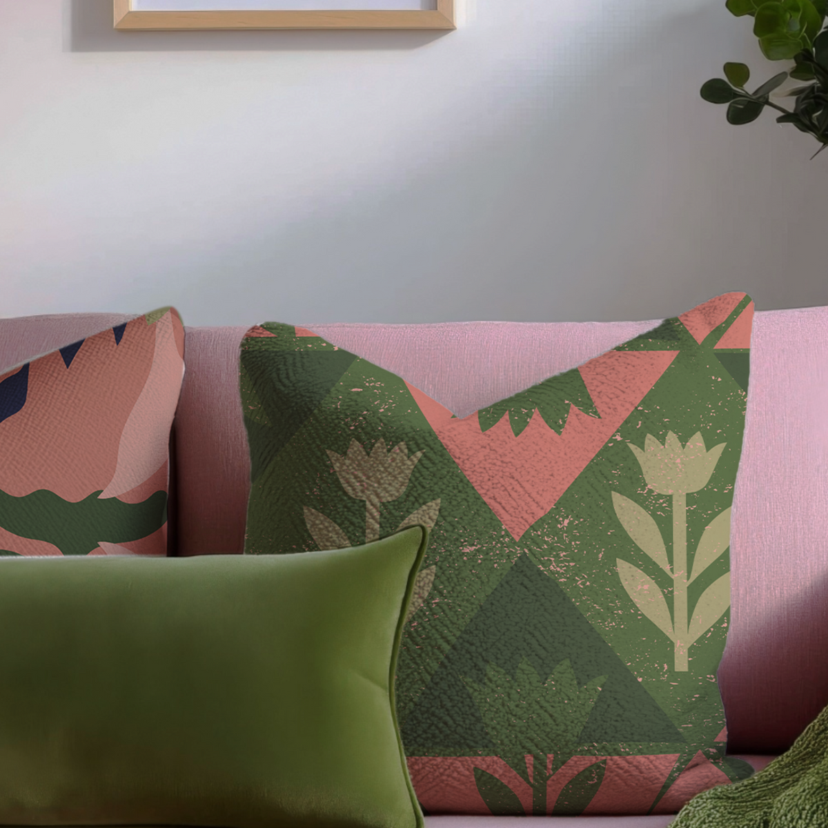 A decorative throw pillow with a geometric quilted pattern in green, pink, and beige, styled on a pink sofa alongside a solid green pillow.