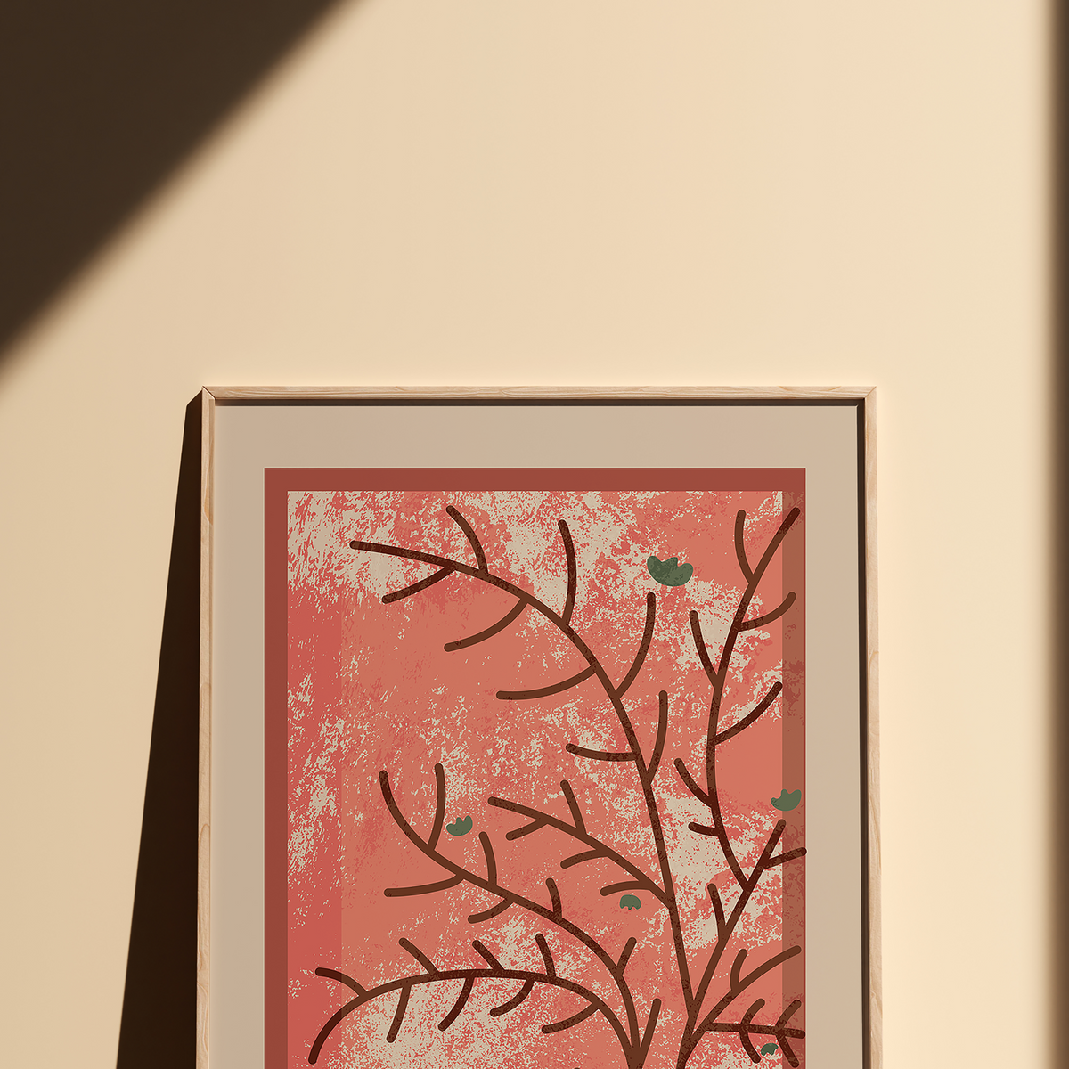A framed botanical art print featuring dark brown branch silhouettes on a textured coral-pink background, displayed on a warm beige wall with a diagonal shadow.