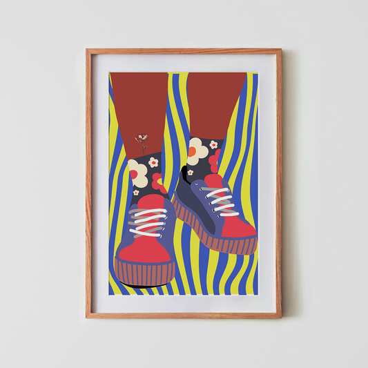 Framed artwork of colourful shoes with floral designs on a white wall