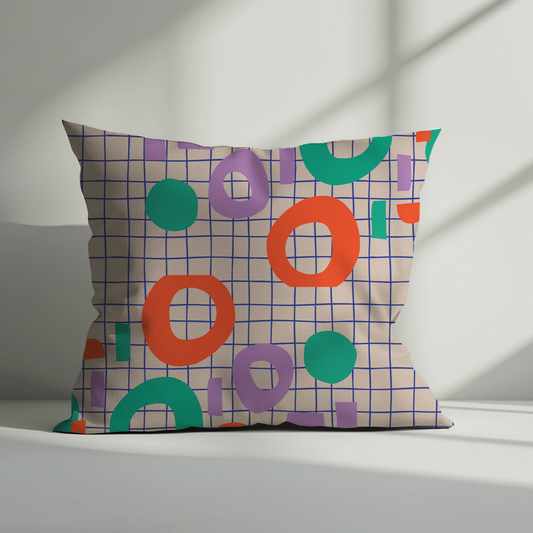 Decorative pillow with colorful geometric pattern on a plain background