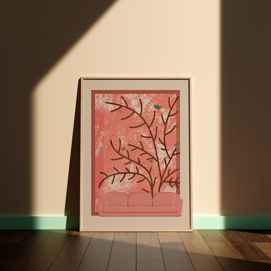 A framed art print featuring a pink sofa beneath stylized brown tree branches on a textured pink background, leaning against a beige wall on a wooden floor with dramatic diagonal sunlight.