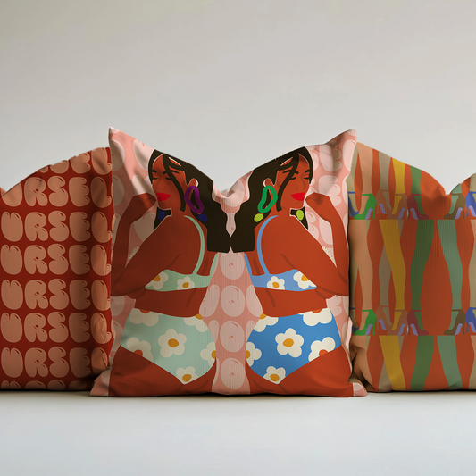 Decorative pillows with artistic designs on a plain background