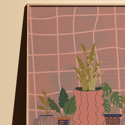 A framed art print featuring a stylized illustration of potted houseplants in front of a pink grid-patterned background, shown hanging on a beige wall.